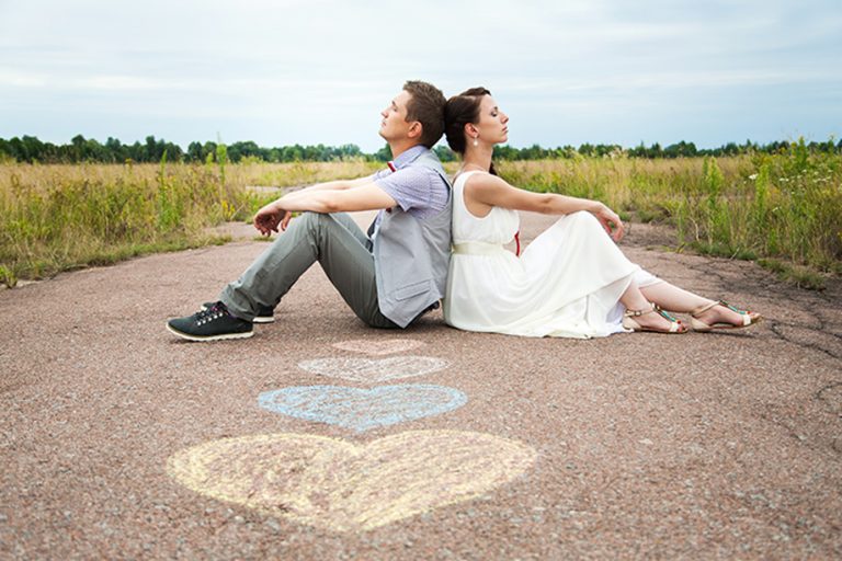 man and woman sitting on the road