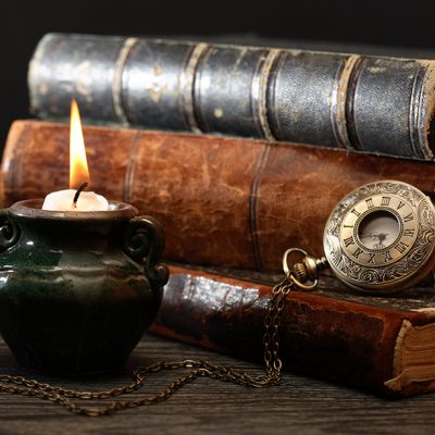 old books, candle and pocket watch