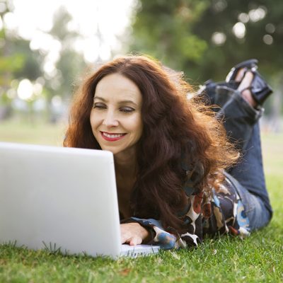 woman using laptop on grass